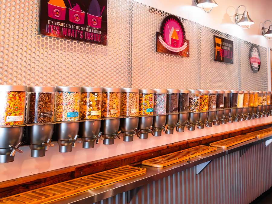 Wall of assorted yogurt topping dispensers